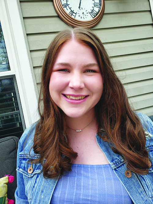 A smiling woman in a blue dress.